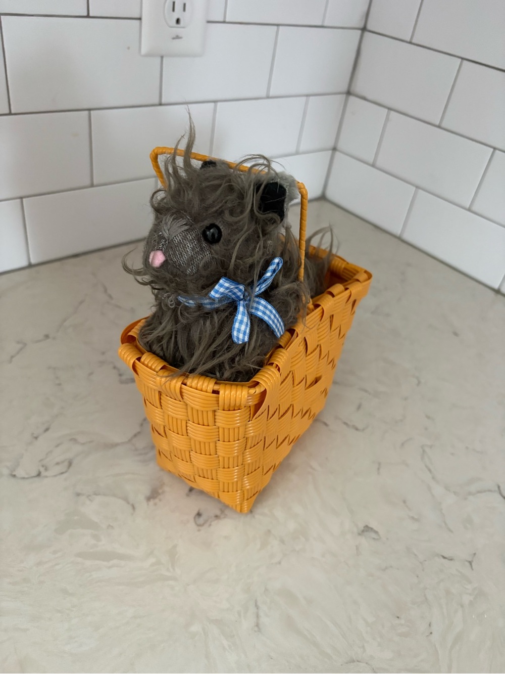 Toto dog plush nestled in a miniature wicker basket, costume prop/accessory